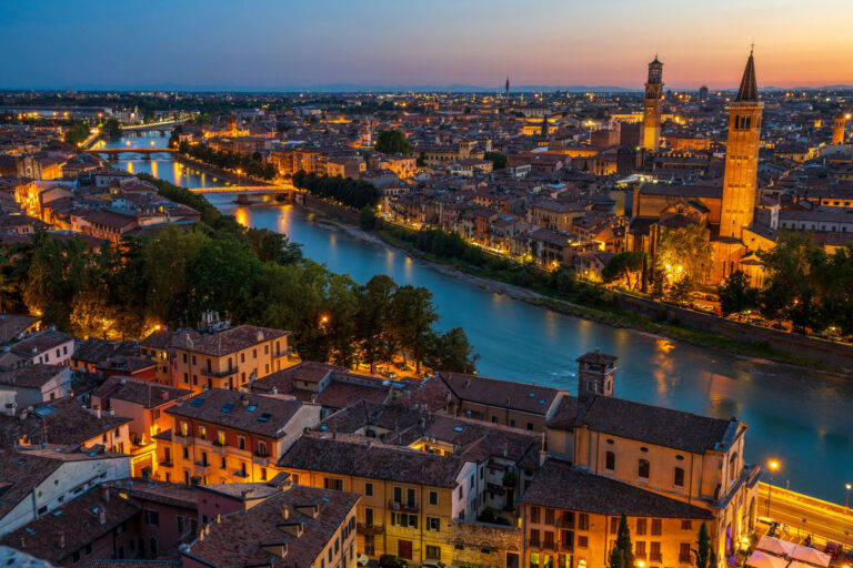 Verona aerial panoramic cityscape of old town historic district with church towers, River Adige, famous landmarks, town squares from Castel San Pietro fortress. Verona, Italy panorama sunset skyline.